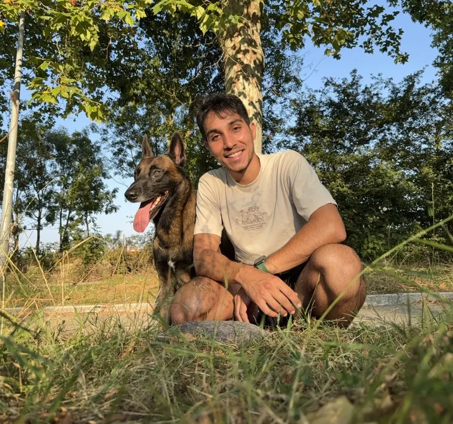 Álvaro López, adiestrador en Vitoria-Gasteiz, agachado junto a su perro Dante, un malinois belga