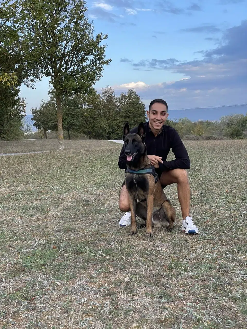 Adiestrador canino celebrando con su cachorro después de una llamada exitosa en casa